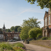 Image of school in Alton, Hampshire with trees in the foreground and church spire above houses in the background